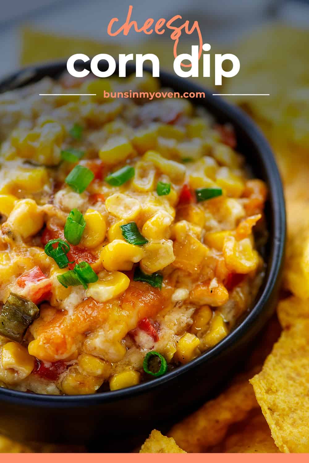 Hot corn dip in black bowl with text for Pinterest.