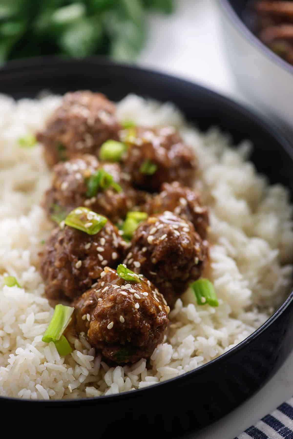 homemade teriyaki meatballs in bowl of rice.