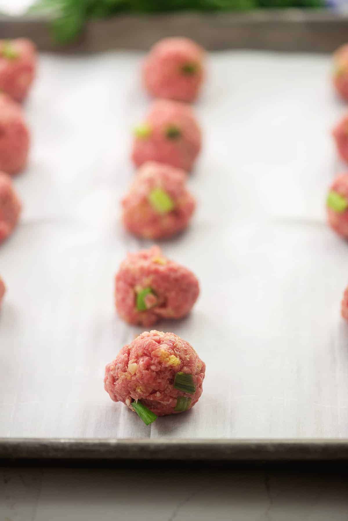 rolled meatballs on baking sheet.