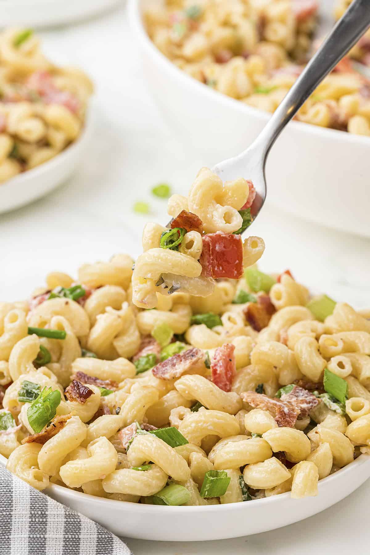 Plate full of BLT pasta salad on fork.