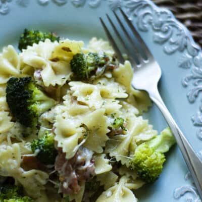 Bacon and mozzarella pasta with broccoli on a decorative plate.