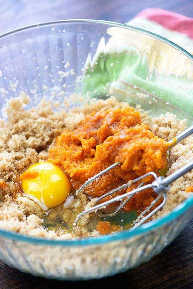 ingredients for pumpkin muffins in bowl with a beater mixing them