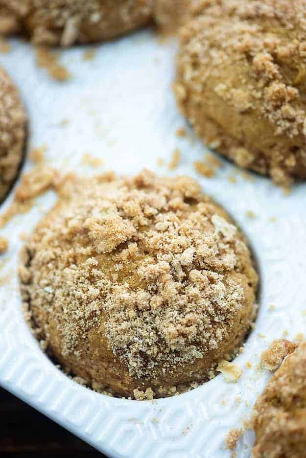 White muffin tin with muffins topped with streusel.