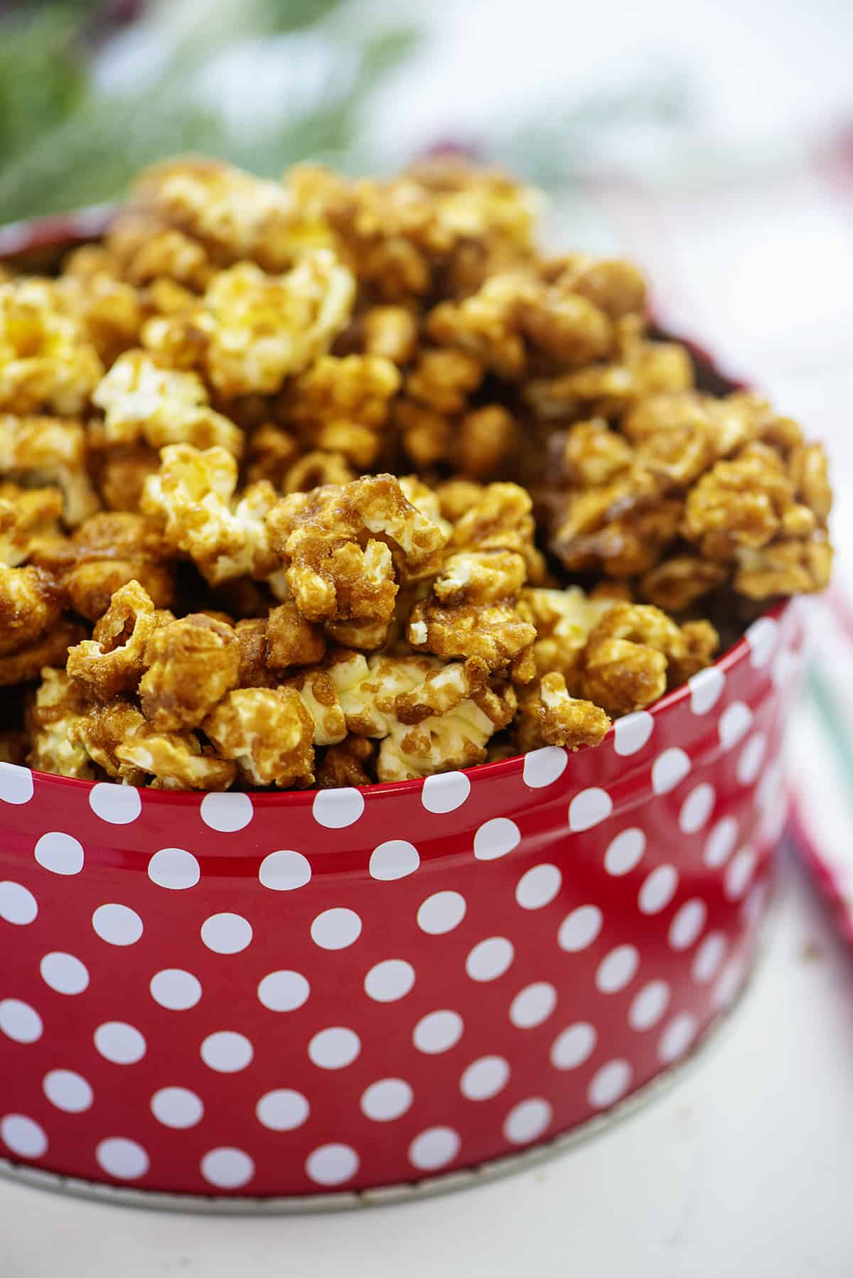 Homemade caramel corn in Christmas tin.