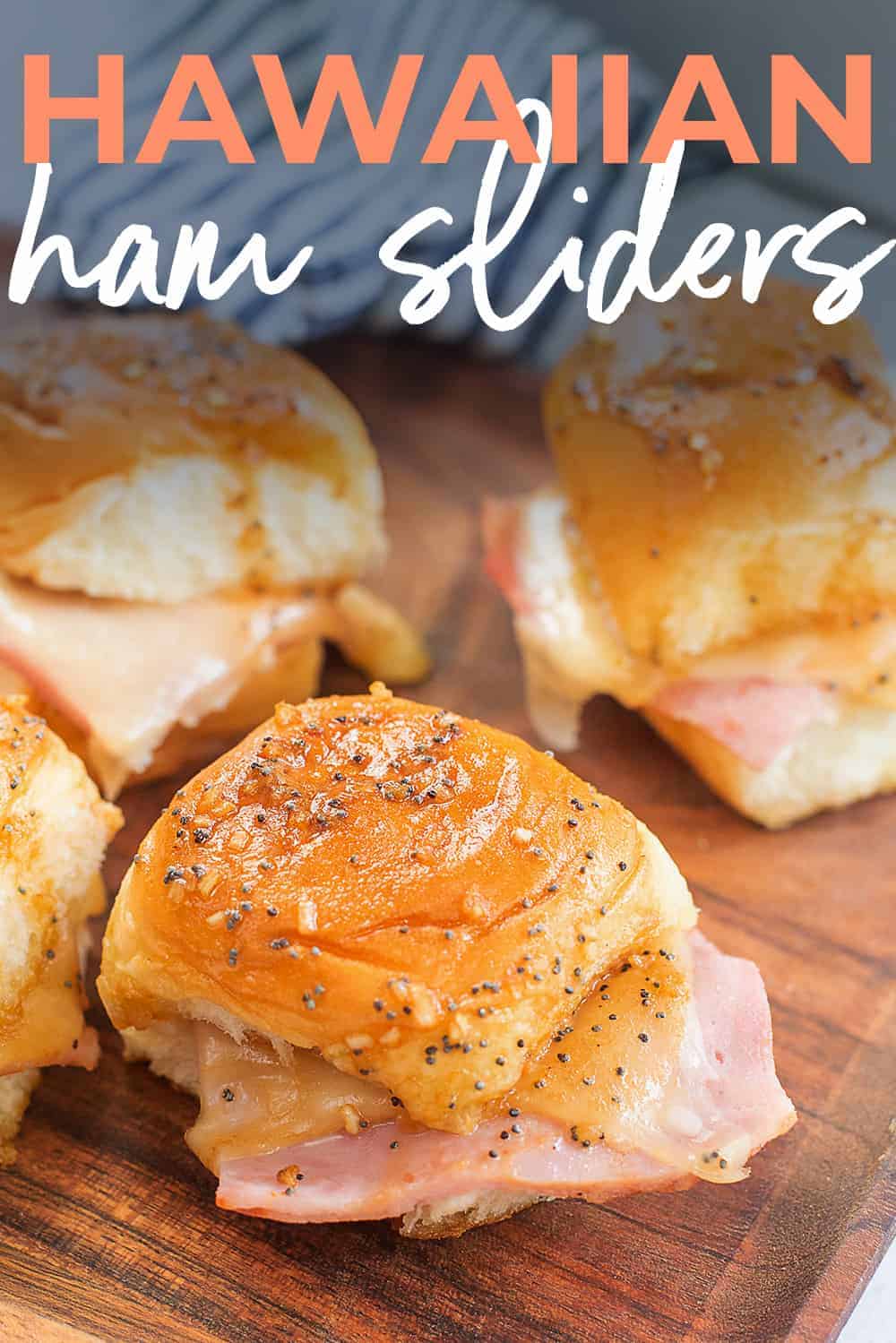 hot ham and chees sliders on wooden cutting board.