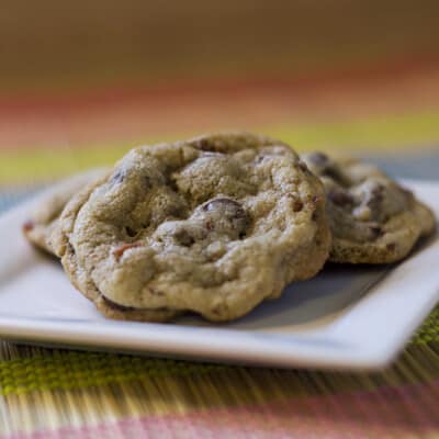 Three chocolate chip and bacon cookies on a square plate