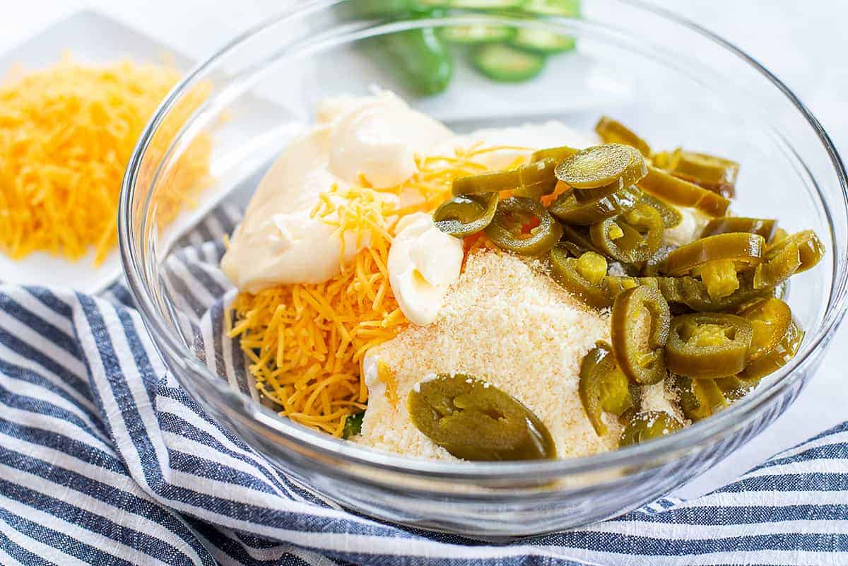 ingredients for jalapeno cheese dip in glass mixing bowl.