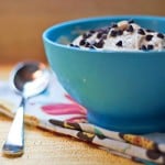 Banana ice cream topped with chocolate chips in a blue bowl.