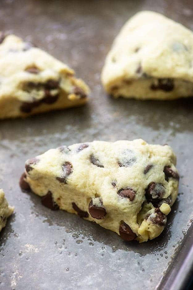 Close up of a chocolate chip scone on a baking sheet.