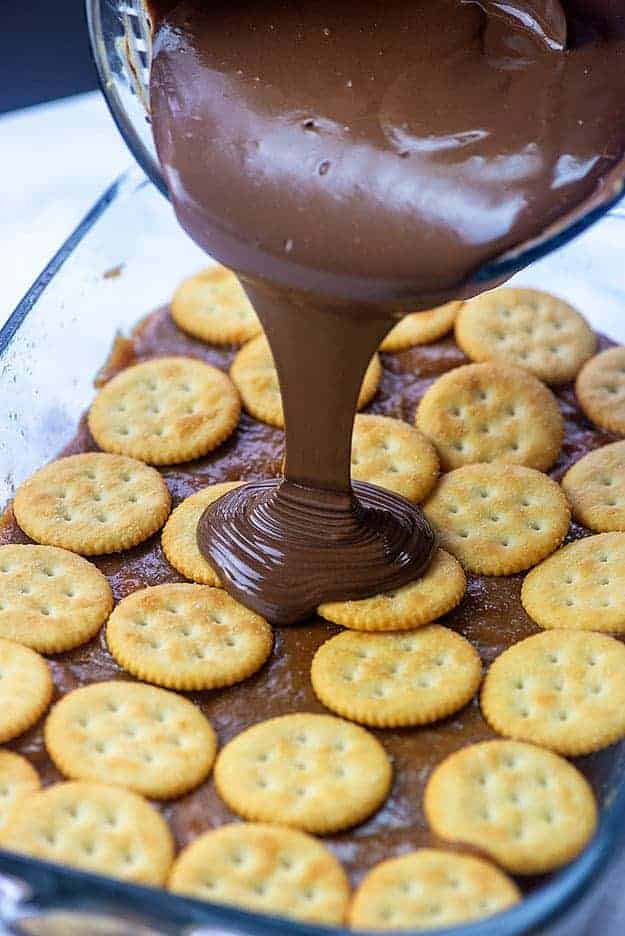 chocolate poured over crackers in glass pan