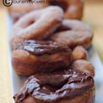 A row of chocolate doughnuts on an appetizer tray