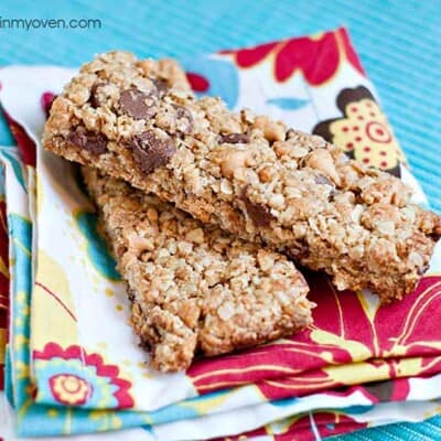 Two granola bars stacked on a folded cloth napkin.