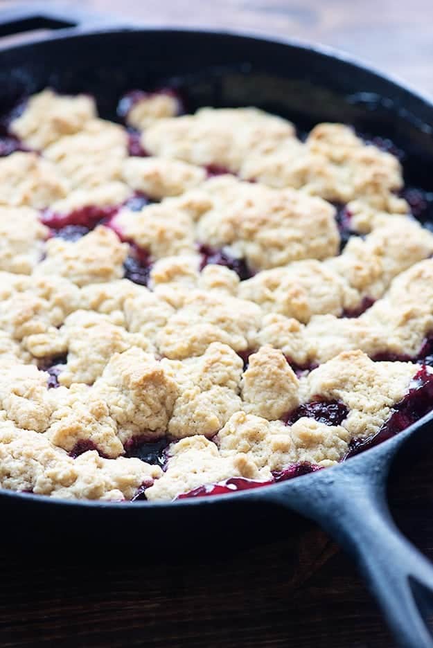 This blackberry cobbler recipe has quickly become our favorite way to make cobbler! The dough on top of the berries is just amazing! blackberry cobbler in cast iron pan