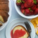 Plate of pound cake next to a bowl of strawberries.