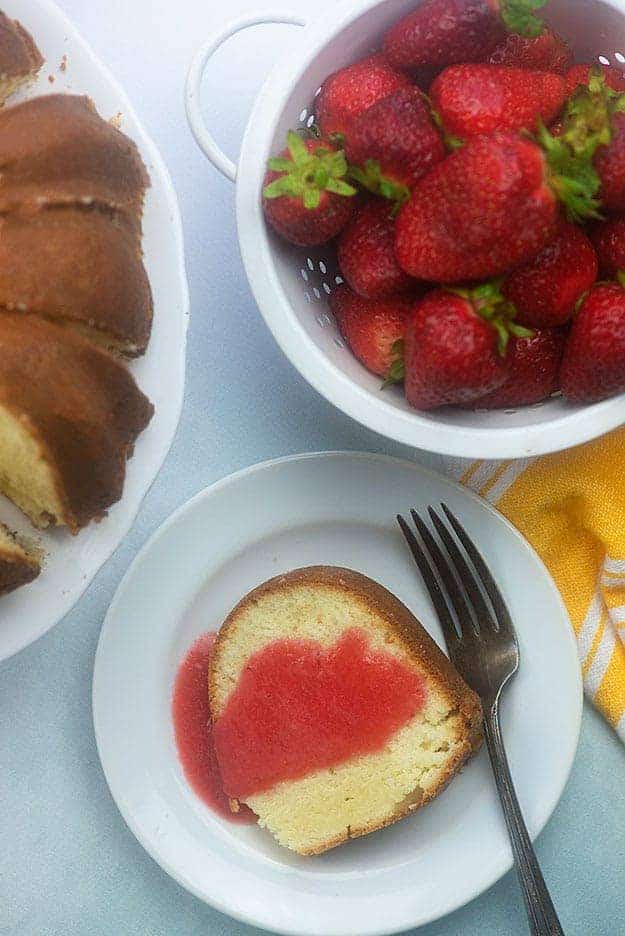 Plate of pound cake next to a bowl of strawberries.