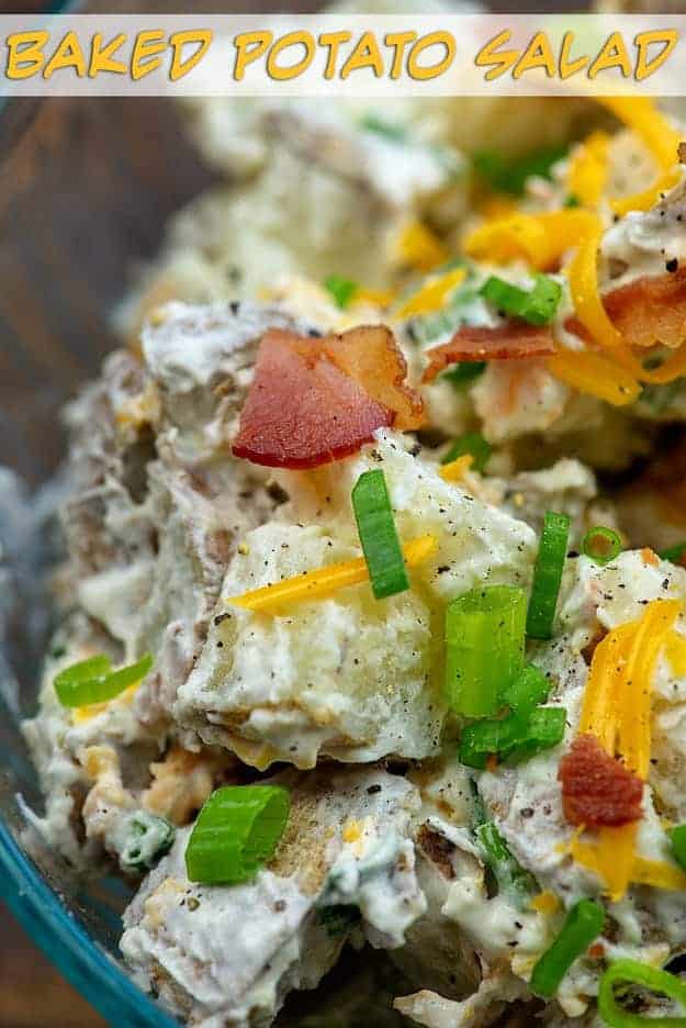 A closeup of bacon and green onions on top of potato salad.
