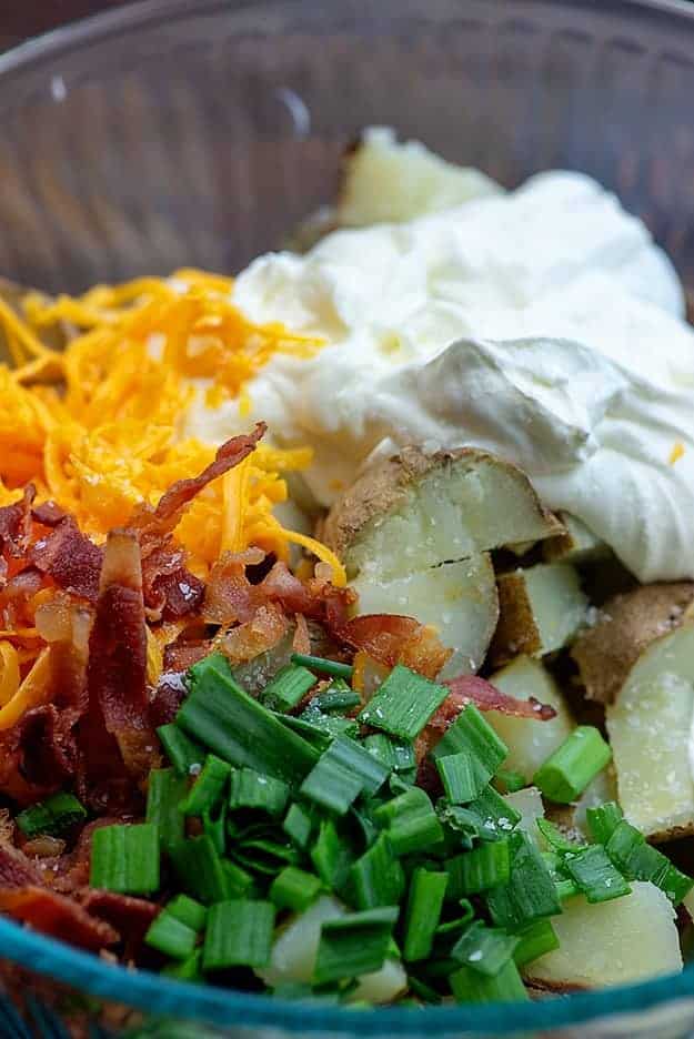 ingredients for loaded potato salad in glass bowl.