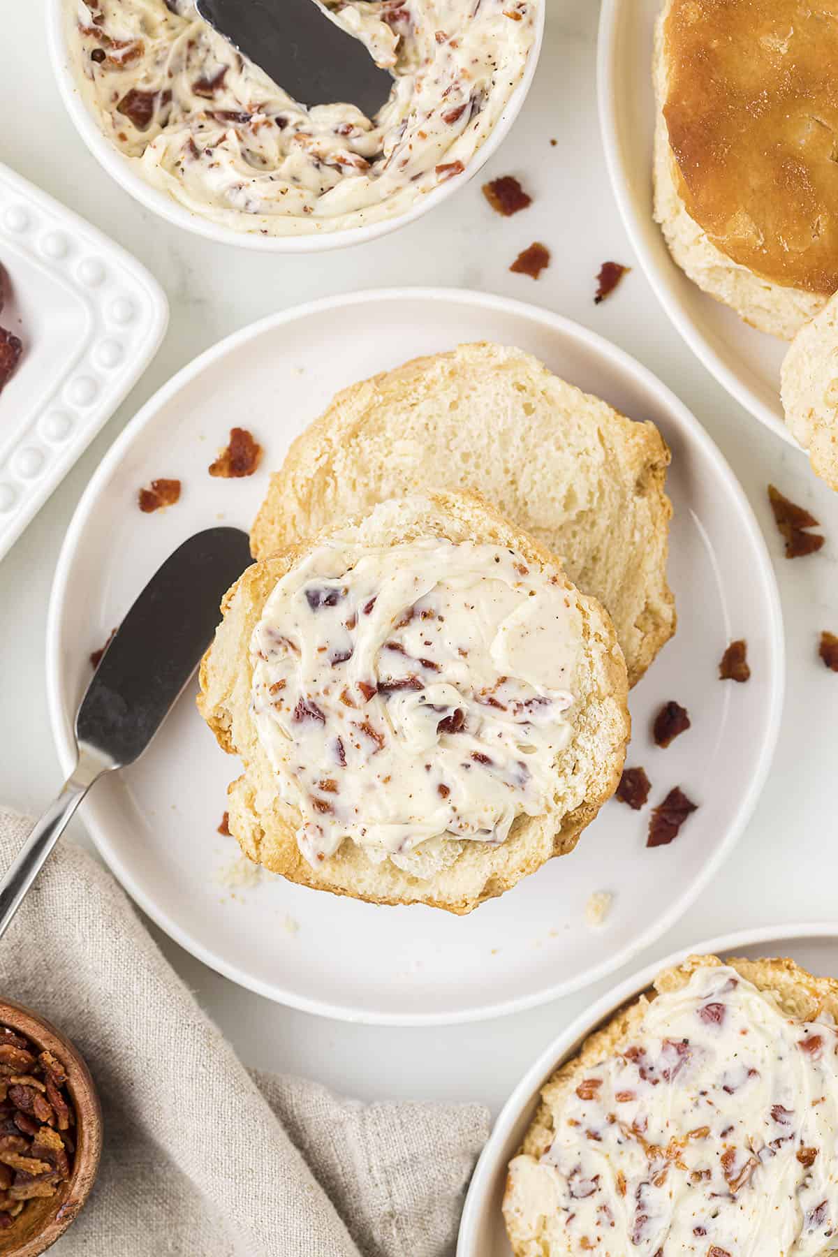 Bacon butter spread on a biscuit on a plate.