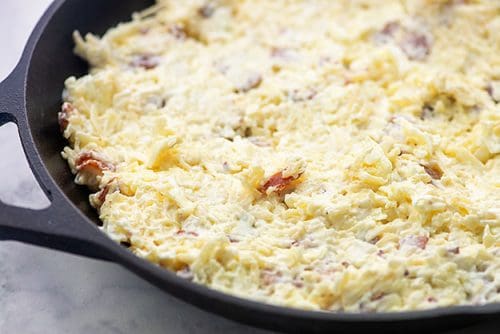 cheese dip with bacon in a skillet ready for baking