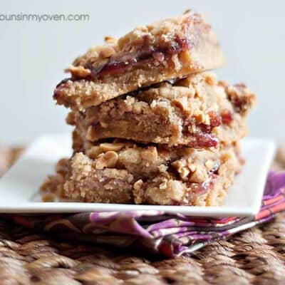 A stack of peanut butter and jelly bars on a square plate