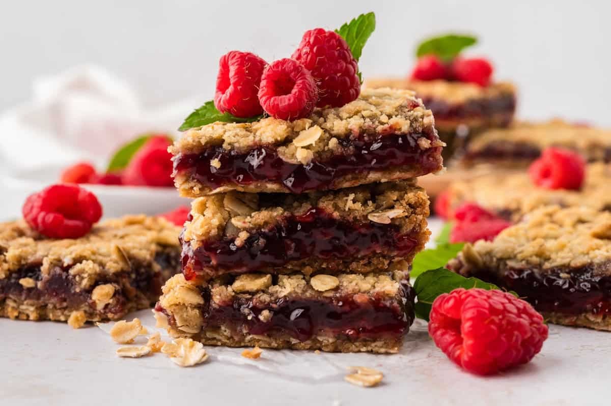 Raspberry oatmeal bars stacked together on counter.