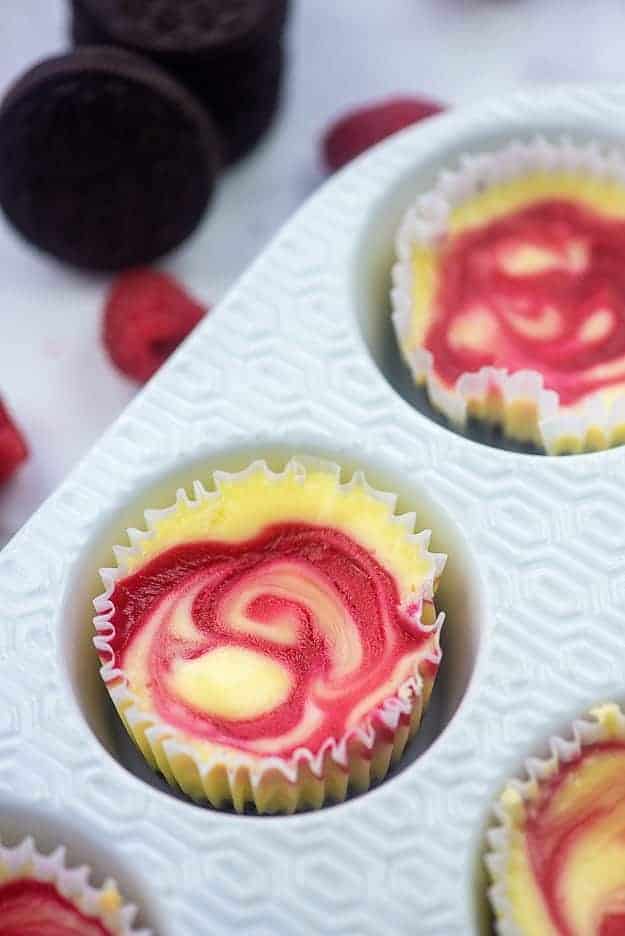 raspberry swirled cheesecake in white muffin pan
