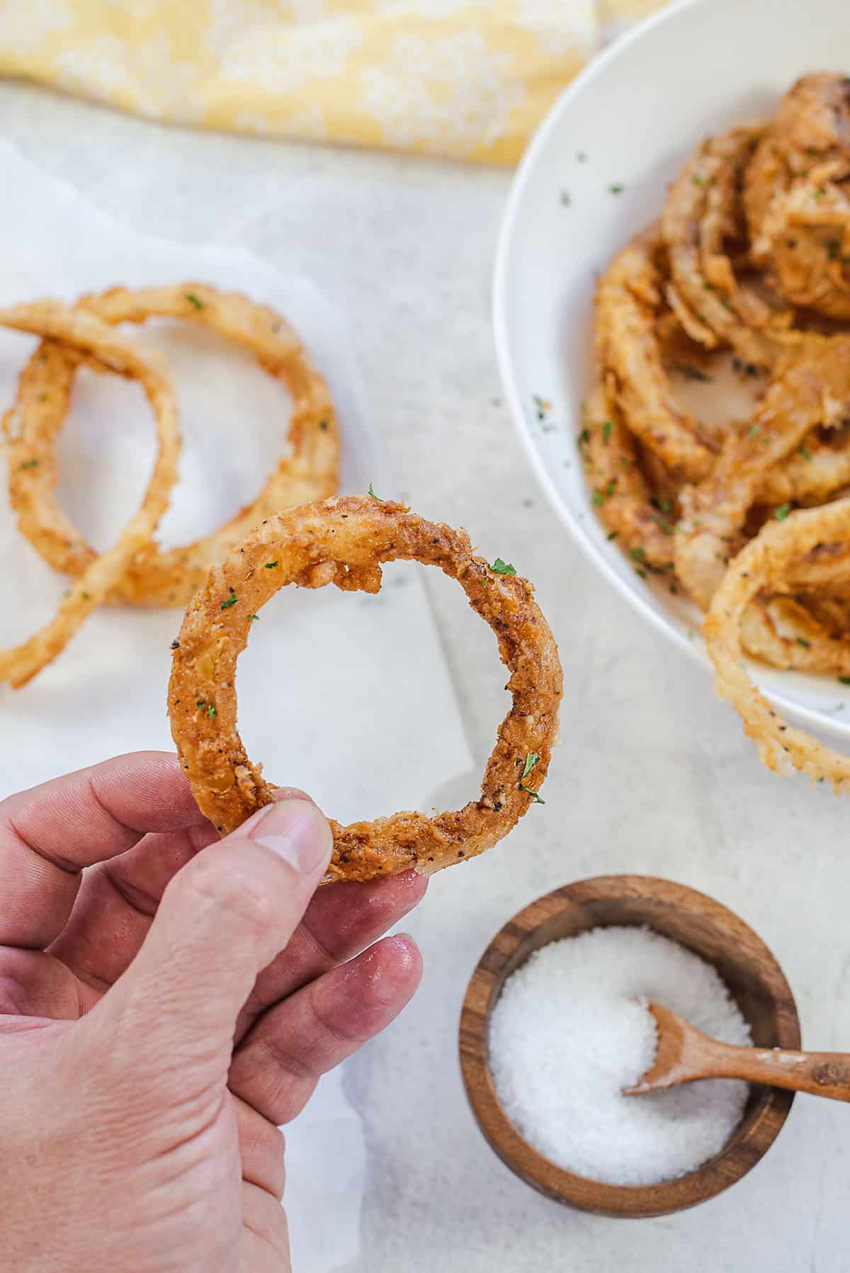 hand holding an onion ring.