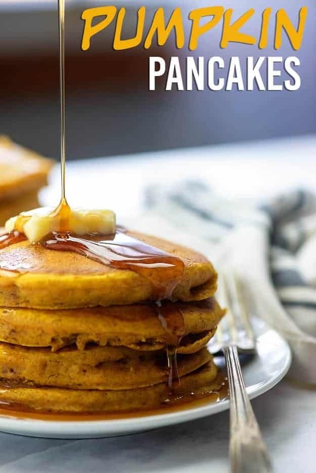 Syrup drizzling over butter on top of pancakes.