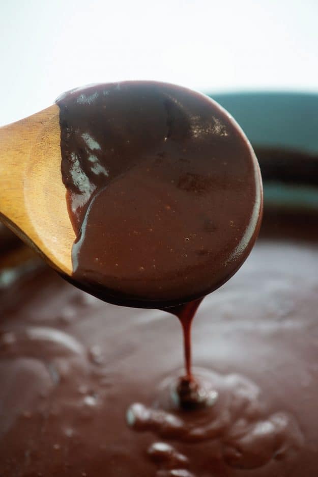 rich chocolate gravy on wooden spoon.