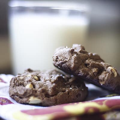 A close up of chocolate peanut butter cookies in front of a glass of milk.