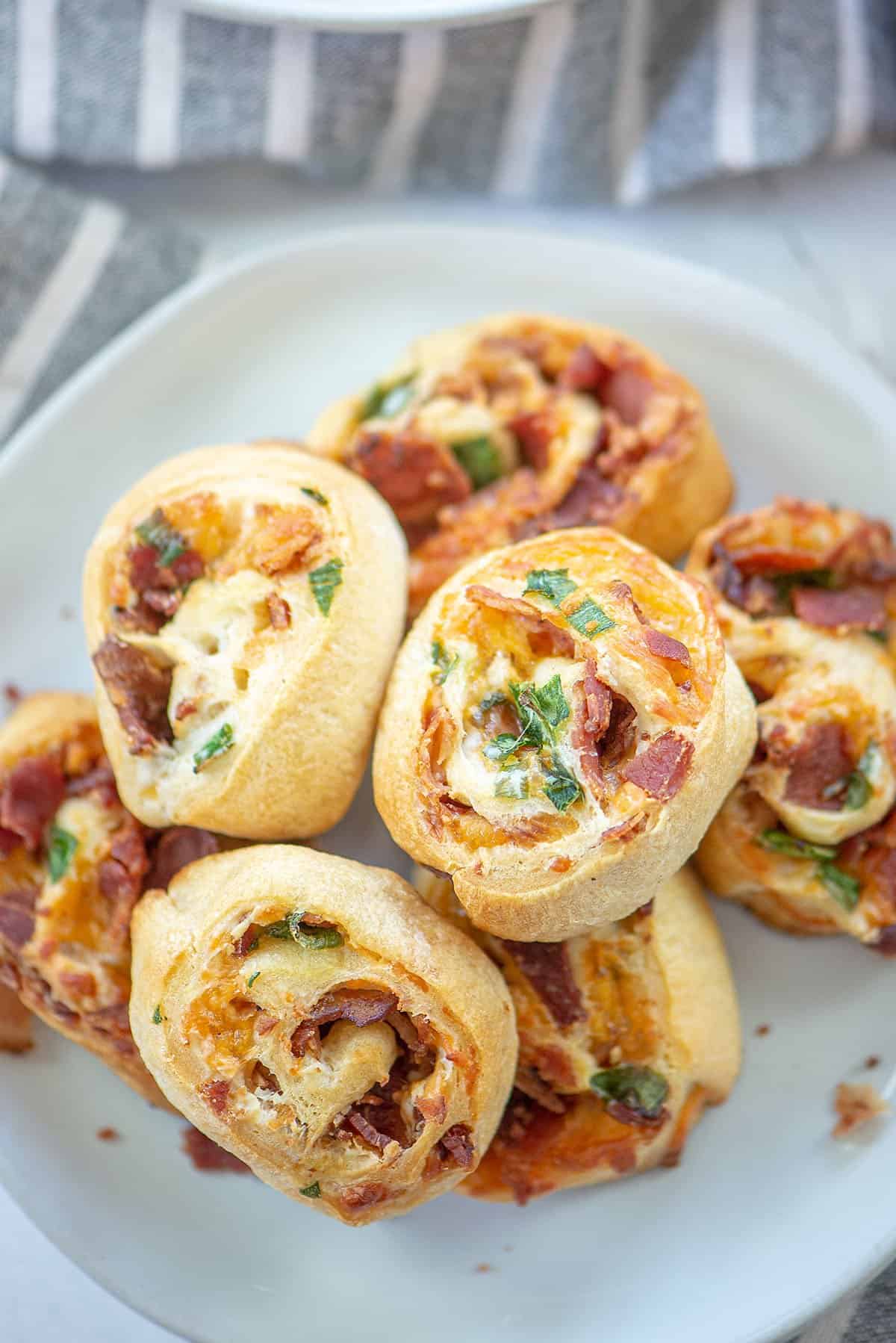 bacon pinwheels on white plate.