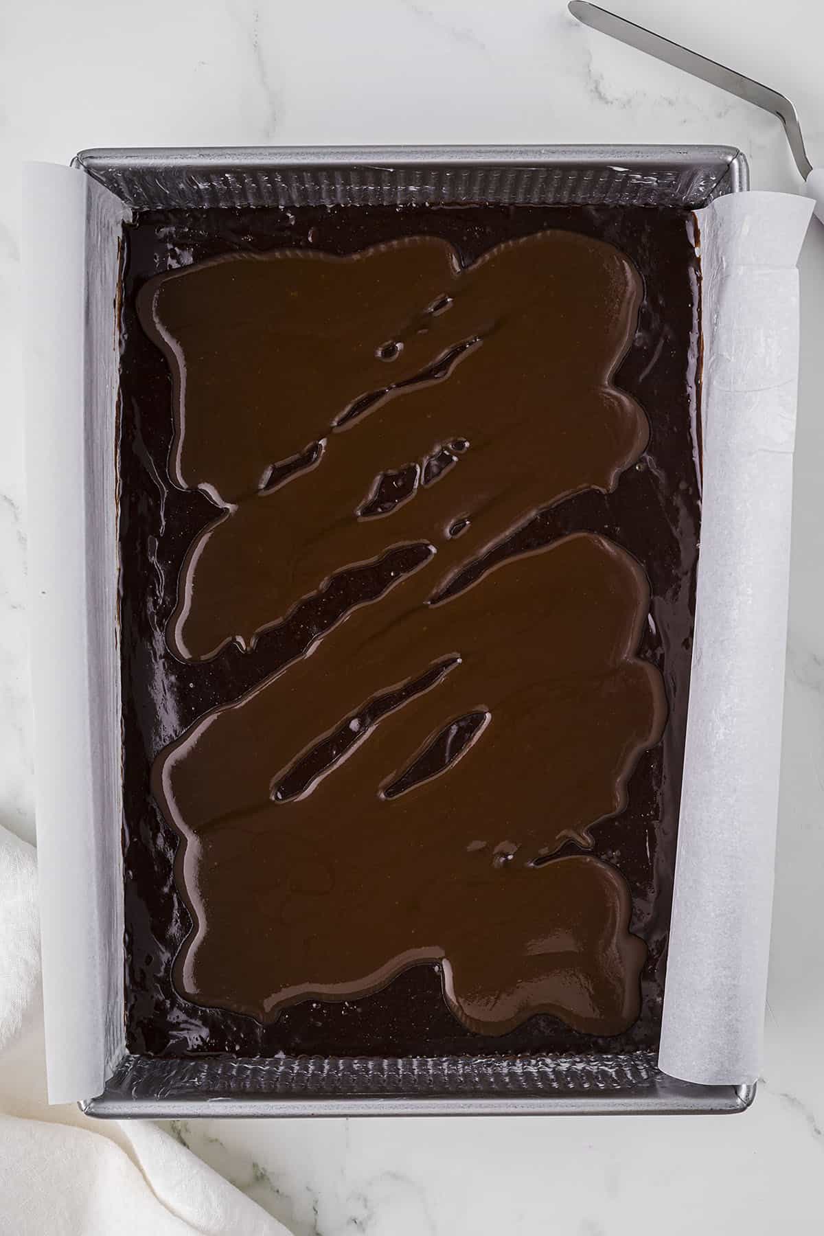 Brownie batter with caramel sauce poured over teh top.