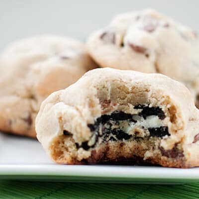 A closeup of a Oreo stuffed chocolate chip cookie with a bite taken out of it