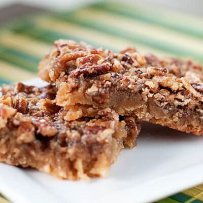 Maple pecan shortbread squares stacked on a square plate