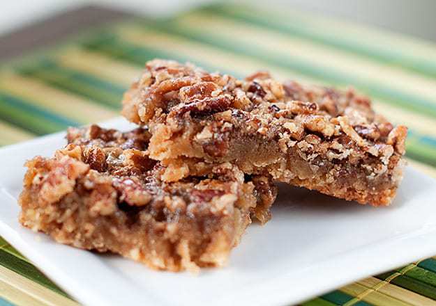 Maple pecan shortbread squares stacked on a square plate