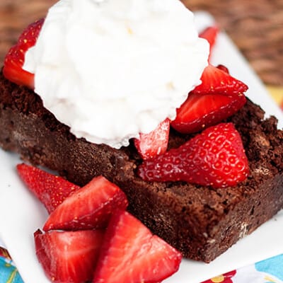 A closeup of chocolate strawberry shortcake topped with whipped cream