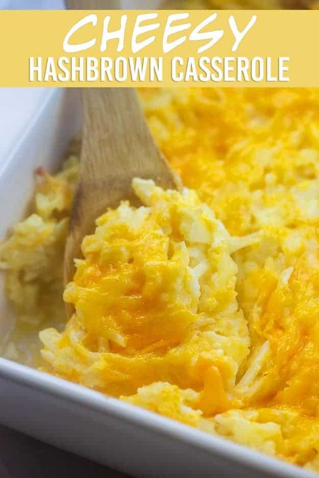 Wooden spoon scooping out cheesy potatoes from a baking pan.