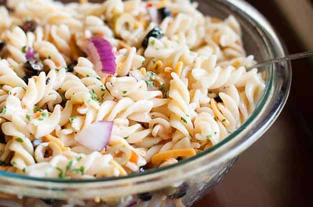 Easy pasta salad served cold in a clear glass bowl.