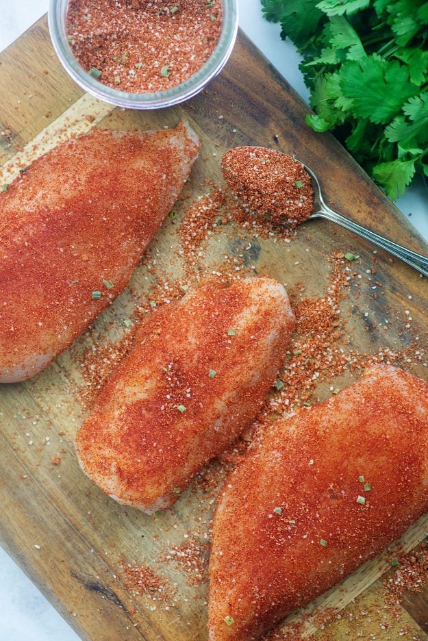 chicken coated in homemade bbq dry rub on wooden cutting board