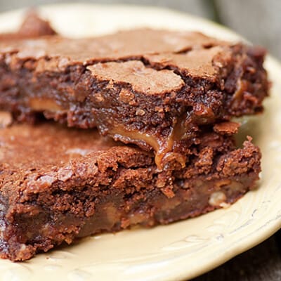 Two stacked up turtle brownies on a plate