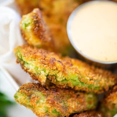 crispy avocado fries piled in dish next to ranch.