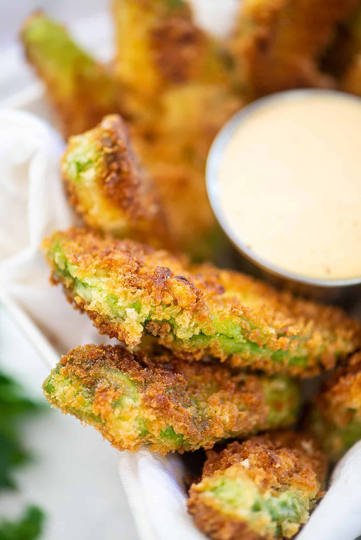 crispy avocado fries piled in dish next to ranch.