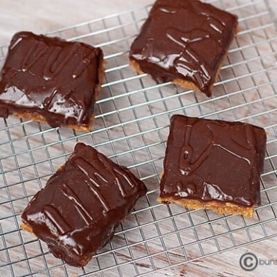 Four peanut butter bars on a wire cooling rack.