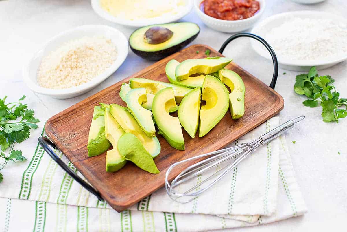 sliced avocado on wooden tray.