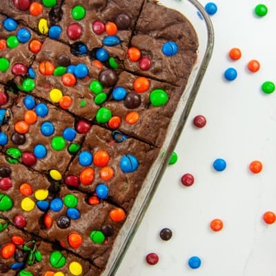 brownies topped with m&m's in glass baking dish.