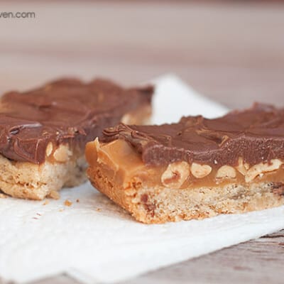 A piece of square peanut butter bars topped with chocolate frosting.