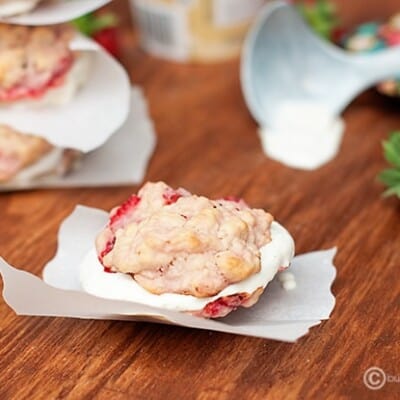 A strawberry shortcake cookie on a torn piece of parchment paper.