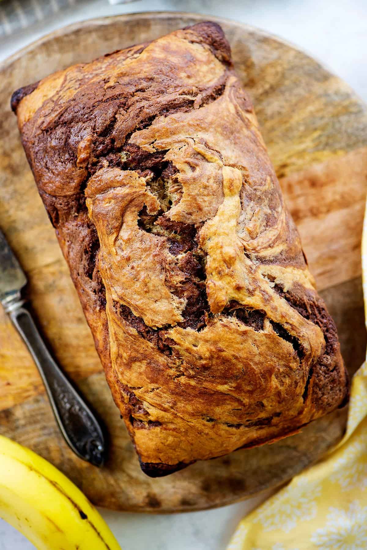 Nutella banana bread loaf of wooden board.