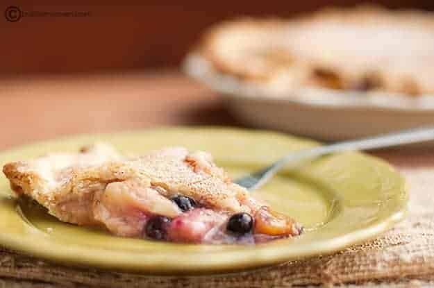 A close up of peach blueberry pie
