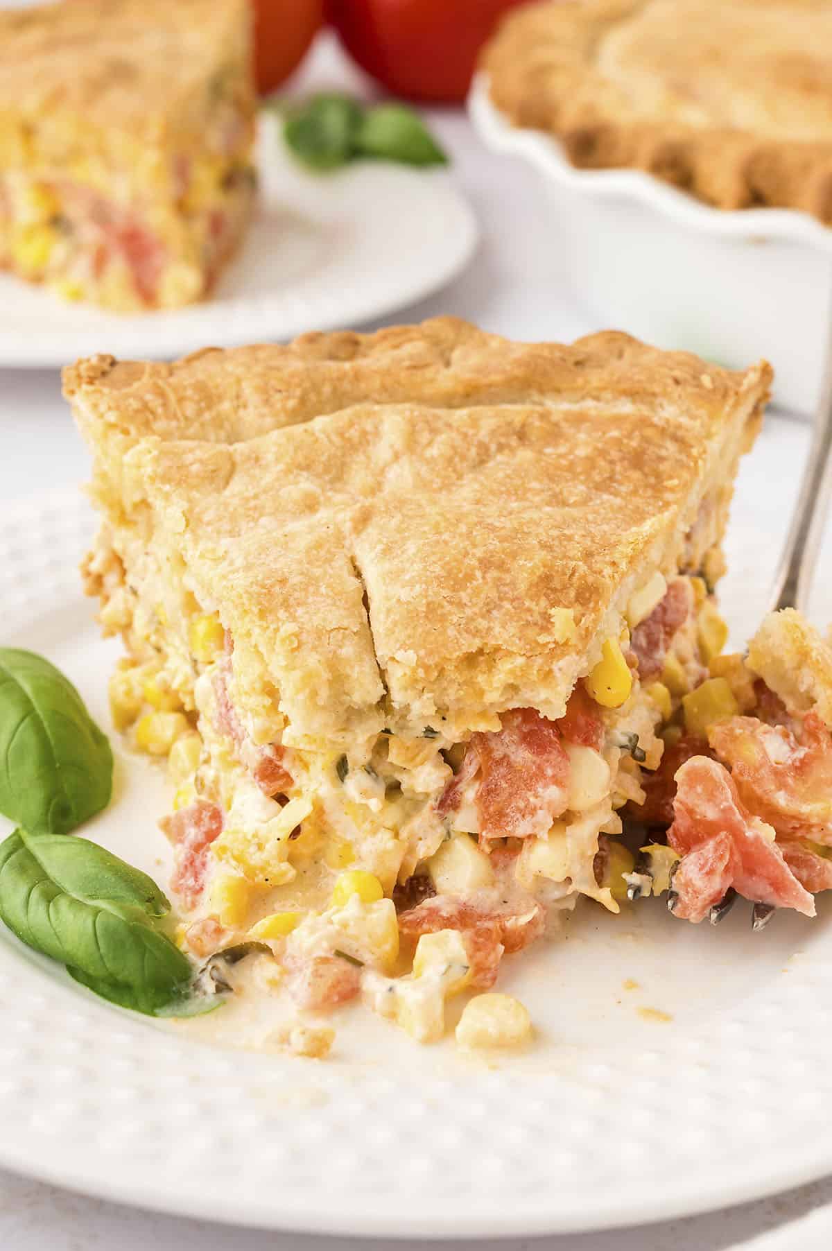 Cheesy tomato pie with a bite taken out.